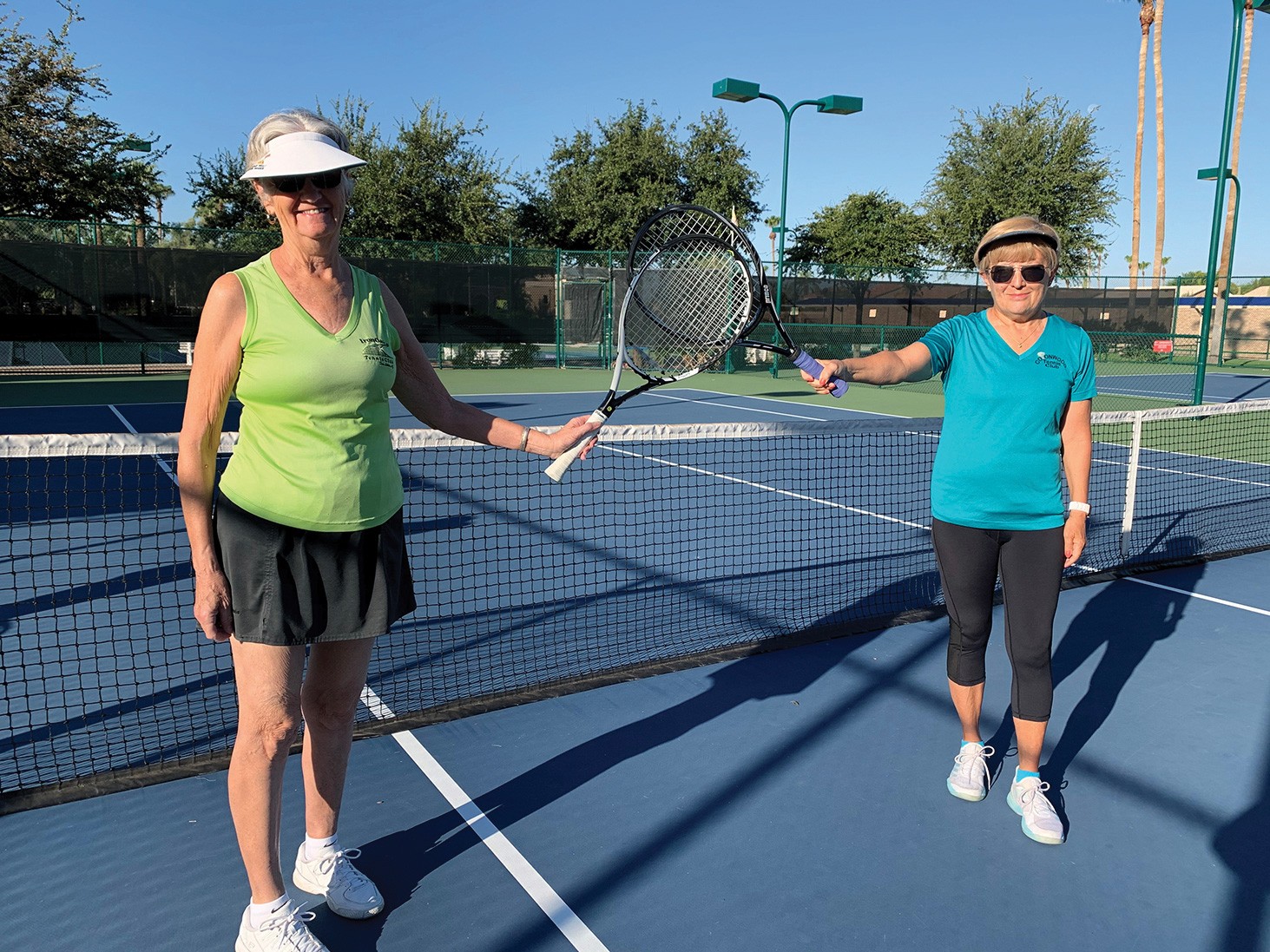 Vivian Guimond and Edith Tanniru warm up for the tennis mixer while social distancing.