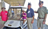 Dedicating the new golf cart at the Southeast Clinic of the VA in Gilbert are (right to left) Art Sharff and Eliott Reiss with small bottle of champagne along with other veterans.