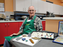 Jim Remer is shown here with some examples of Lapidary. In the foreground are “slabs.” These are flat portions that were cut with stone saws from larger stones (sometimes as large as 24 inches thick). Slabs are inspected for quality, further cut with smaller stone saws, then shaped and polished on grinding wheels to become beautiful gems. These are then set in metal for wearable jewelry.