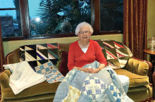 Sue Sossaman displays one of the historic quilts she will talk about at the annual P.E.O. Coffee.