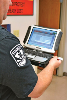 Sun Lakes Fire Department Emergency Medical Services Coordinator Chris Barden demonstrates how the flash drive inserts into the electronic patient care report tablet that is carried by SLFD paramedics on calls. (Photo and article by Brian Curry)