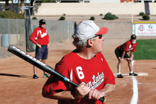 Bill Cheney is ready to swing away during a recent contest. In the background is third base coach Evan Hansen and base runner Larry Maggerd. (Photo courtesy of Core Photography)