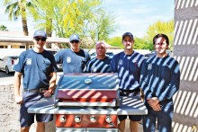 Sun Lakes firefighters from the Department’s Station Two proudly pose with their new fire engine red BBQ grill.