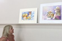 Joyce Ennis admires paintings awaiting critiques