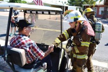 Battalion Chief Rob Helie thanks a Sun Lakes World War II veteran for his service as the gentleman cheered the SLFD group on.