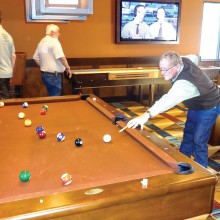 League member Willie Foster playing pool in the Billiards Room at Robson Ranch, Casa Grande, with Keith McDonald and Fritz Derheim in the background.