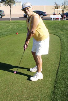 Susan Powell is taking a practice shot as she prepares for a morning round with her Lady Putters group.