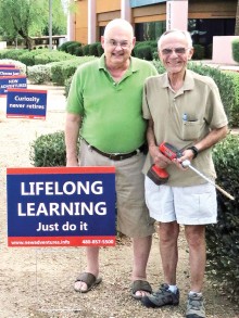 Ed Schauble and Wayne Wright install new signs promoting the New Adventures fall semester.