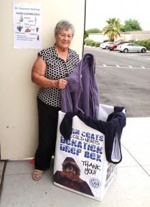 Betty Perry, chair of the Warm Coats Drive, preparing warm clothing to be donated to needy families.