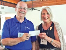Eric Ehst receives an $800 check from Ocotillo Women’s League Community Chairman Cheri Morgan.