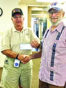 Jay Sanderson, Commander of Korean War Veterans Association, giving a monetary donation to the Stand Down Foundation, received by representative Art Sloan.