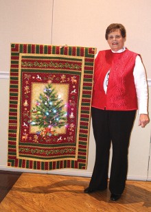 Judith Kraker, Agave member and professional quilter, shares her delightful light-up Christmas quilt with attendees at the holiday party.