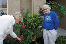 Diane Beatty and Nancy Sjolin with rose bushes.