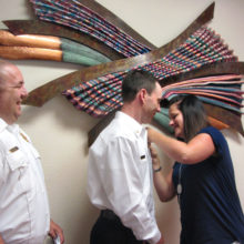 Sun Lakes Fire District Chief Troy Maloney (left) beams as Shawn Helie, wife of newly promoted Deputy Chief Rob Helie, pins his new Deputy Chief’s badge on him. Deputy Chief Helie has risen through the SLFD ranks and takes over for retiring Deputy Chief Dan Guerra. (Photo by LouAnn Sedgwick; caption by Brian Curry).