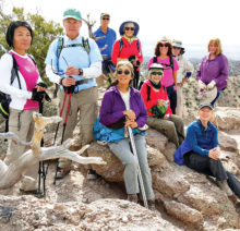 Hikers enjoying view atop tent rocks in New Mexico.