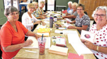 Volunteers assemble new greeting cards by recycling the fronts and messages from used greeting cards. The newly created cards, called Crystal Cards, will be sold and the proceeds donated to My Sister’s Place.