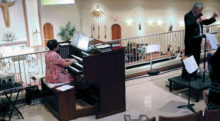 Sun Lakes resident Bill Bade conducts the Risen Savior Chancel Choir, Hand Bell Choir, and instrumentalists in the award winning Easter Sunday performance of James Chepponis’ Christ Is Risen. Carla Robertson accompanies on the organ (photo by John Freund).