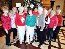 Ladies Billiards Club members gather in front of the Christmas tree before their annual Christmas luncheon at Stone & Barrel.