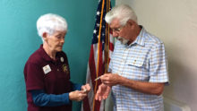 Past zone chairman Bob Neale of the Nanoose Bay Lions in British Columbia, Canada, exchanged club pins with SLBLC President Donna O’Neill. (Photo by Brian Curry)