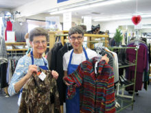 Sun Lakes residents Nancy Smith (left) and Barb Dubler display boutique clothing for sale in the new Assistance League of East Valley thrift shop. Proceeds clothe 7,500 needy schoolchildren.