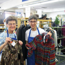 Sun Lakes residents Nancy Smith (left) and Barb Dubler display boutique clothing for sale in the new Assistance League of East Valley thrift shop. Proceeds clothe 7,500 needy schoolchildren.