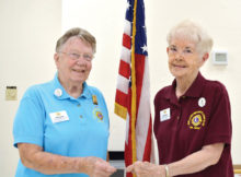 Lion Donna Quinn (left) is presented with the “Lions International Silver Centennial” pin for bringing in new members to the SLBLC.