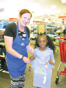 April Joy of Sun Lakes helps Lauren Perkins, a second grader at Webster Elementary in Mesa, pick out a new outfit.