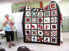 Diana Jones is showing the beautiful quilt that her mother Bobbie Woodward made from a basket of quilt blocks she received from her quilt group at a Holiday Party in the White Mountains, Show Low area.