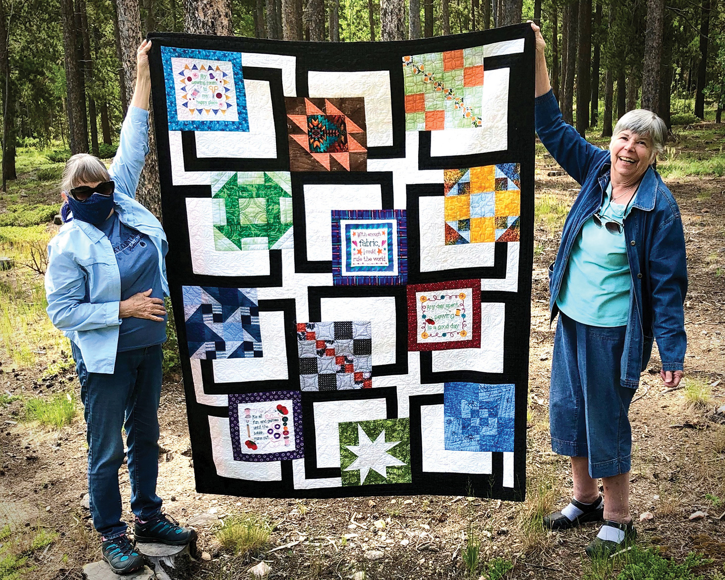 Outgoing President Sue Bart and her neighbor Maureen Sherman are shown displaying Sue's quilt. We asked Sue to remove her face mask for the picture. Look, they both have on jackets. Ah, to be cool again!