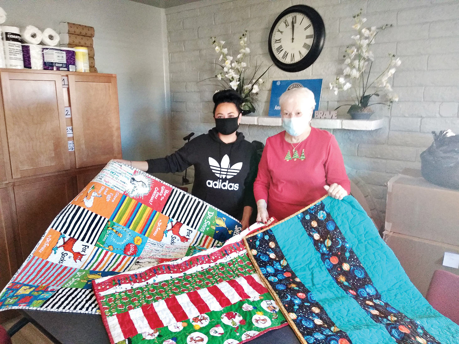 These are a few quilts made by Desert Threads members. Nancy Bonngard (right) presented 18 quilts recently to Nayre (left) at My Sister's Place.
