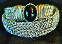 Bracelets by Henry Huss: The bottom is an 18-strand, 18-gauge, sterling silver wire weave. The top bracelet is a weave using 22-gauge sterling silver wire with gold wrap and an onyx stone.