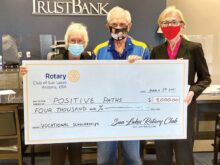 Sun Lakes Rotary members Marie Fotino and Howard Rudge present a check to Sandra Hudson from Trust Bank and a Positive Paths board member.
