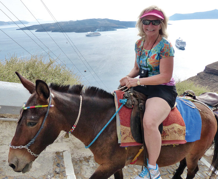 Cheryl Hungate riding a donkey up to Santorini, Greece, before COVID